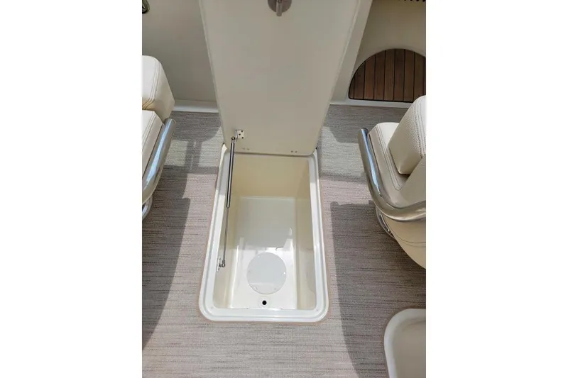 Slide: The Image of 2024 Chris-Craft Launch 27 interior storage compartment with beige seating and carpet. - 14