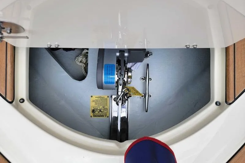 Slide: The Image of 2024 Chris-Craft Launch 27 anchor compartment with winch and safety warning label. - 15