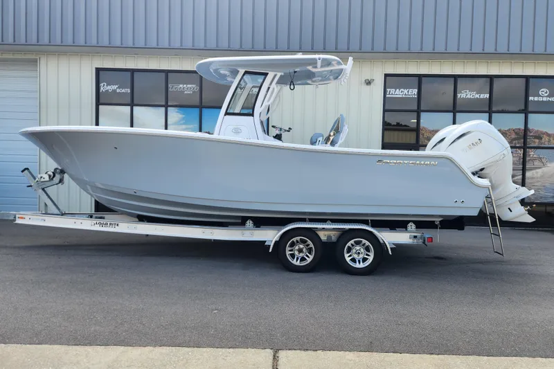 The Image of 2026 Sportsman Open 252 Center Console boat on trailer outside dealership. - 0