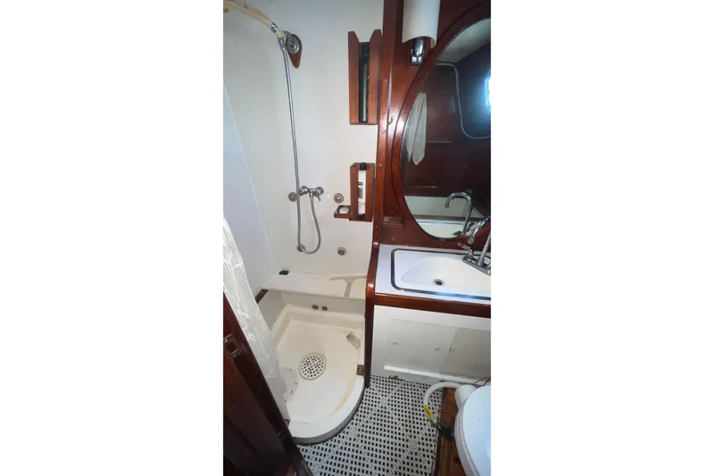 Slide: The Image of 1977 Gulfstar 50 yacht bathroom with shower, sink, and wooden accents. - 33