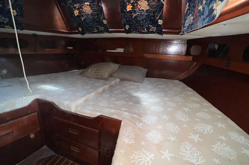 Slide: The Image of Cozy cabin interior of a 1977 Gulfstar 50 sailboat with nautical-themed bedding. - 35