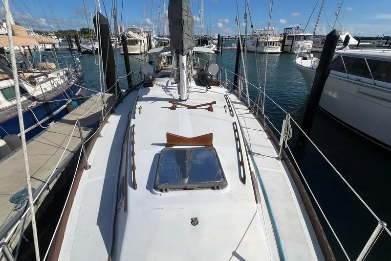 Slide: The Image of 1977 Gulfstar 50 sailboat docked at marina, surrounded by other boats. - 6