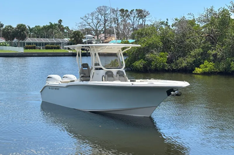 The Image of 2026 Key West 260 CC boat on a calm river, surrounded by lush greenery. - 0