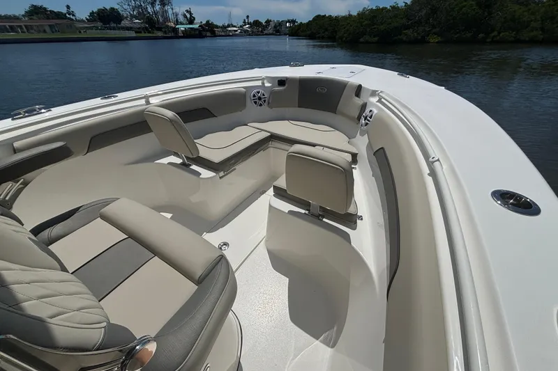 Slide: The Image of 2026 Key West 260 CC boat interior with cushioned seating on a calm waterway. - 13