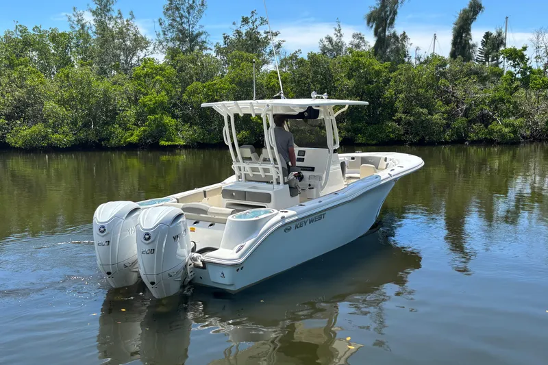 Slide: The Image of 2026 Key West 260 CC boat with dual engines on a calm river. - 2