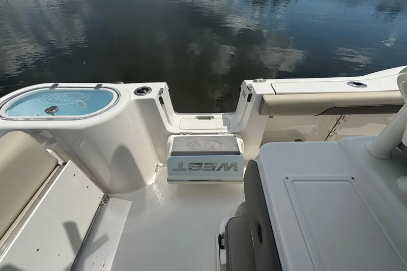 Slide: The Image of 2026 Key West 260 CC boat interior with seating and storage, docked by calm water. - 7