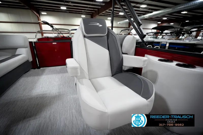 Slide: The Image of 2026 Bennington 20 SSR boat interior with modern seating and cup holders in showroom. - 25