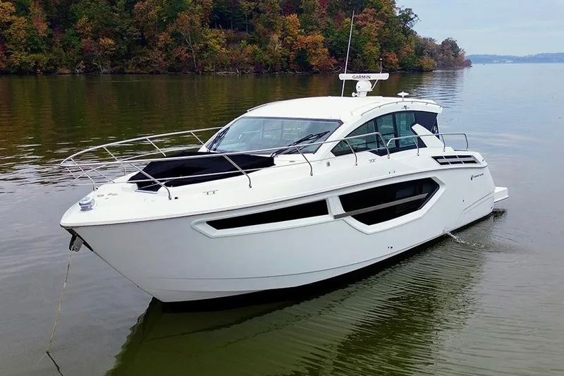 The Image of 2020 Cruisers Yachts 42 Cantius on calm water, surrounded by autumn trees. - 0