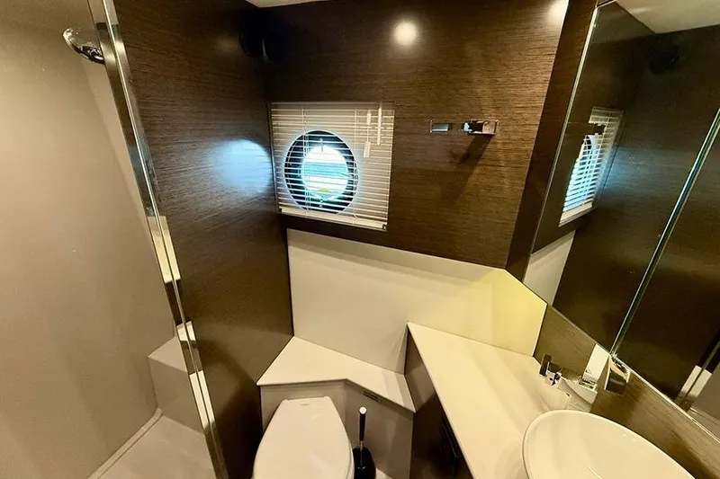 Slide: The Image of Luxurious bathroom interior of 2020 Cruisers Yachts 42 Cantius with modern fixtures and porthole window. - 10