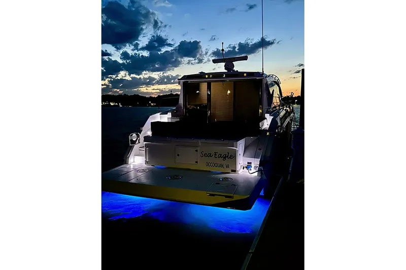 Slide: The Image of 2020 Cruisers Yachts 42 Cantius at sunset with blue underwater lights. - 2