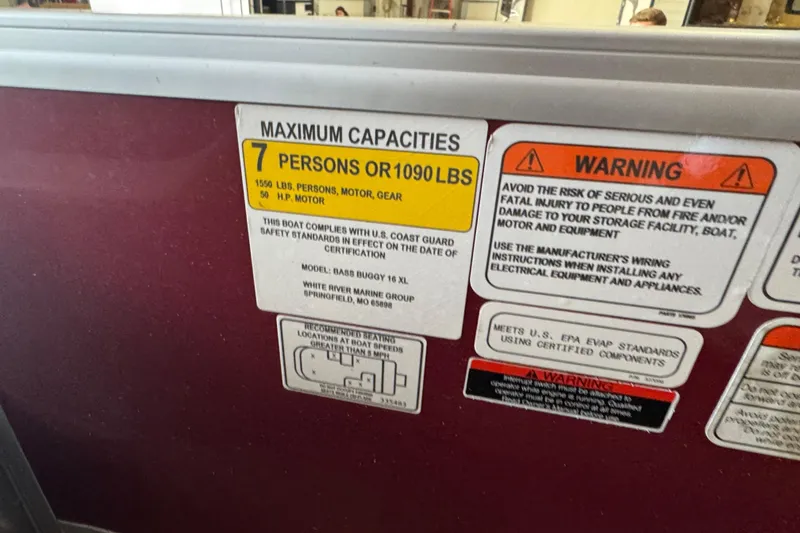 Slide: The Image of 2023 Sun Tracker Bass Buggy 16 XL Select capacity and safety warning labels. - 12