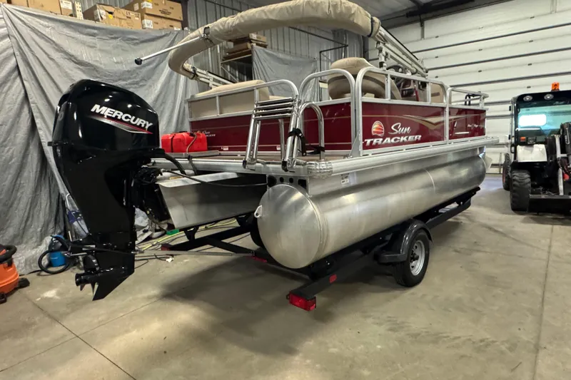 Slide: The Image of 2023 Sun Tracker Bass Buggy 16 XL Select pontoon boat with Mercury engine in a garage. - 4