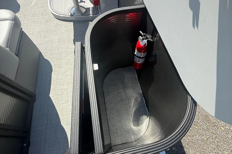 Slide: The Image of Open storage compartment with fire extinguisher on 2025 Crest Classic 200 boat. - 11