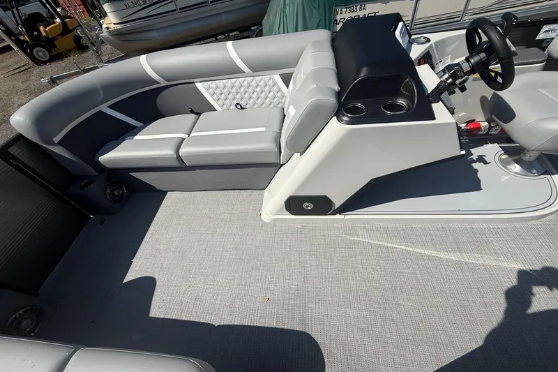 Slide: The Image of 2025 Crest Classic 200 pontoon boat interior with gray seating and steering console. - 16