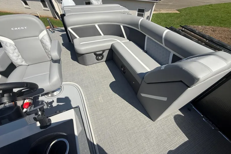 Slide: The Image of 2025 Crest Classic 200 pontoon boat interior with gray seating and steering wheel. - 21