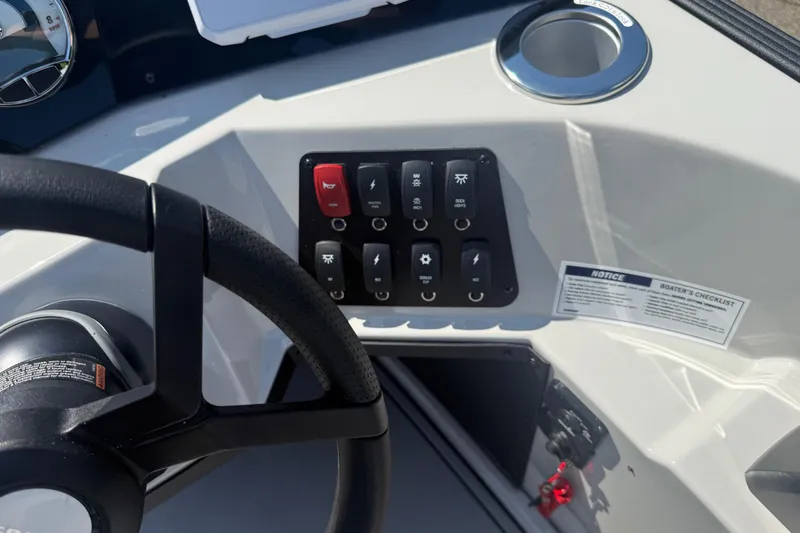 Slide: The Image of Steering wheel and control panel of 2025 Crest Classic 200 boat, featuring switches and boater's checklist. - 27