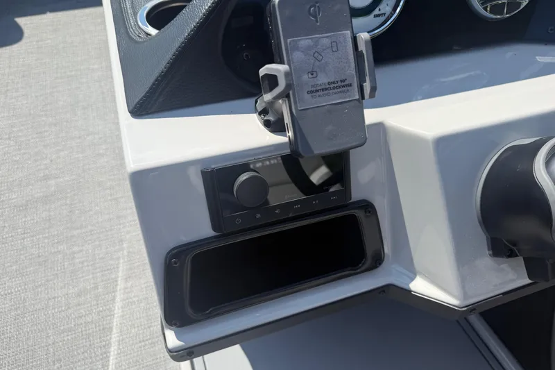 Slide: The Image of Dashboard of 2025 Crest Classic 200 boat with phone holder and control panel. - 28