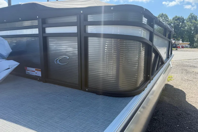 Slide: The Image of 2025 Crest Classic 200 pontoon boat, sleek design, parked outdoors under blue sky. - 3