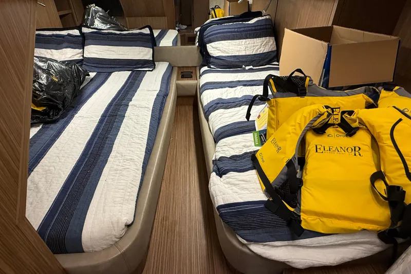 Slide: The Image of 2018 Chris-Craft Commander 44 cabin with striped bedding and yellow life jackets. - 15