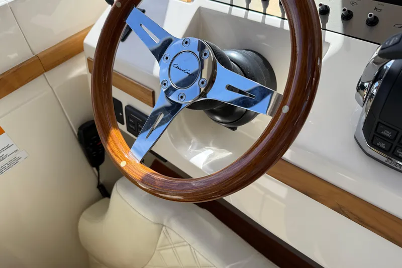 Slide: The Image of Steering wheel of 2018 Chris-Craft Commander 44 boat, featuring wood and chrome accents. - 7