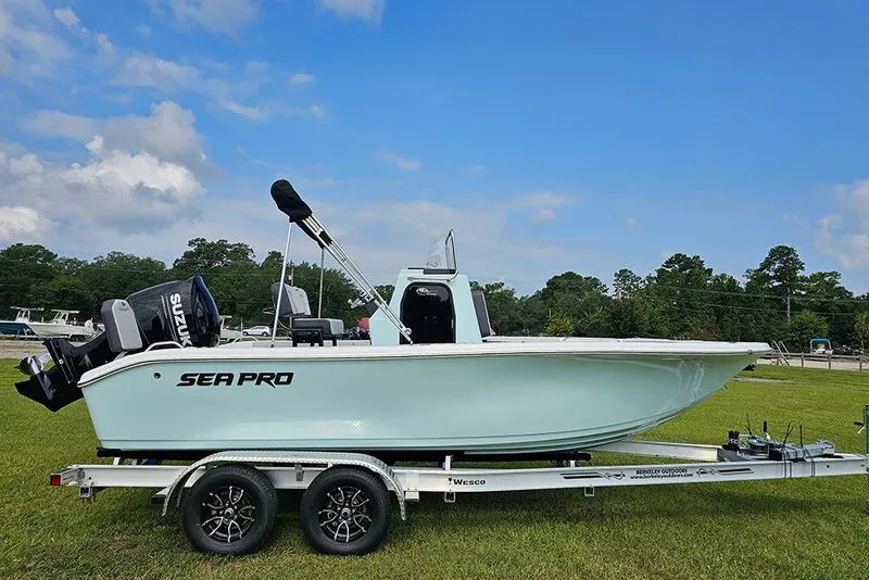 The Image of 2026 Sea Pro 202 Center Console boat on trailer, parked on grass under blue sky. - 0