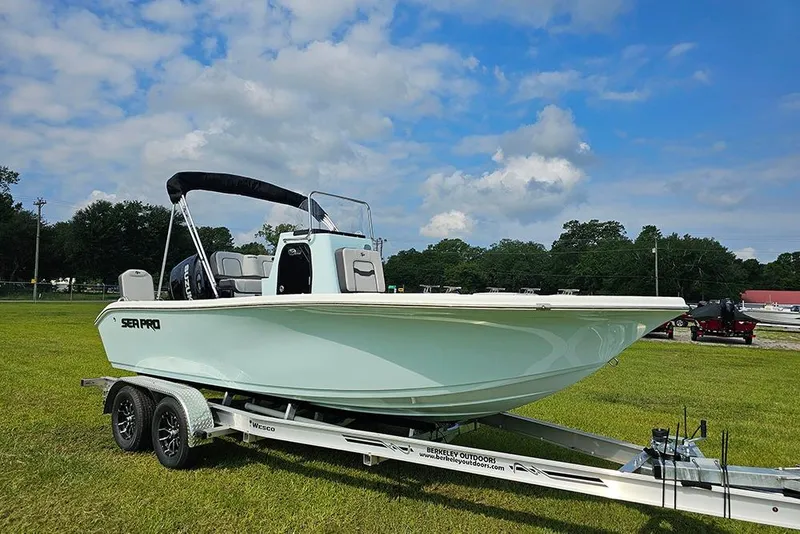 Slide: The Image of 2026 Sea Pro 202 Center Console boat on trailer, displayed outdoors under blue sky. - 1