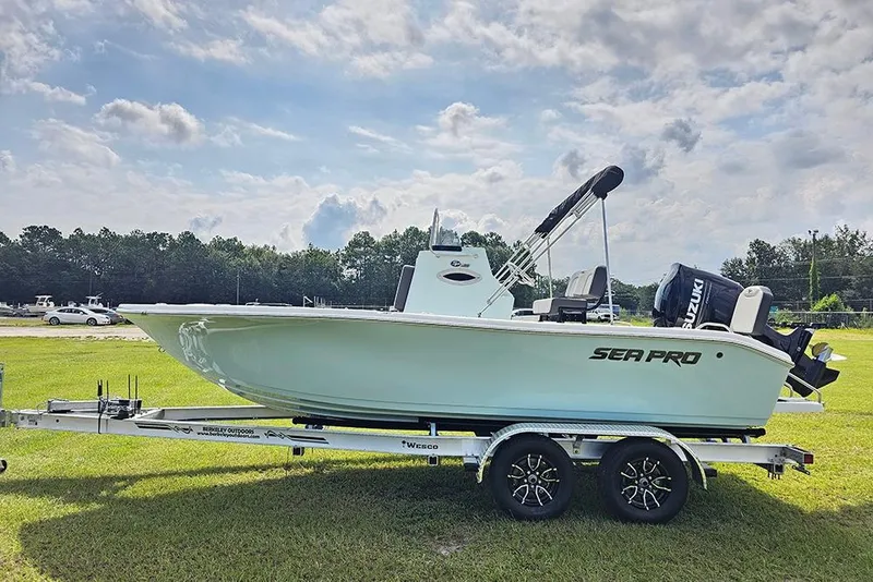 Slide: The Image of 2026 Sea Pro 202 Center Console boat on trailer, parked on grass under cloudy sky. - 5