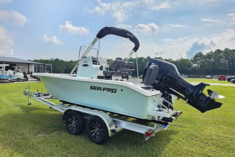Slide: The Image of 2026 Sea Pro 202 Center Console boat on trailer, parked on grass under a blue sky. - 6
