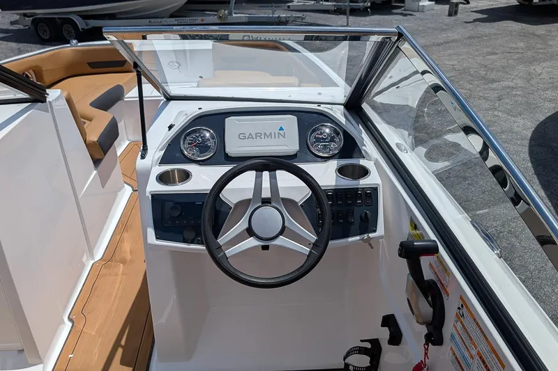 Slide: The Image of 2023 Hurricane SunDeck 235 OB boat dashboard with Garmin navigation system and steering wheel. - 10