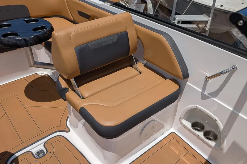 Slide: The Image of 2023 Hurricane SunDeck 235 OB boat interior with tan and black seating, cup holders, and table. - 11