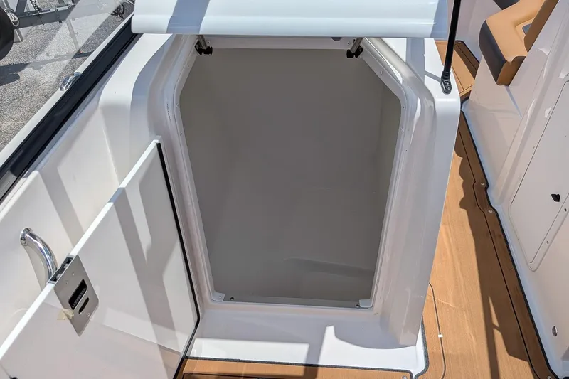 Slide: The Image of 2023 Hurricane SunDeck 235 OB boat storage compartment with open hatch, showcasing interior space. - 13