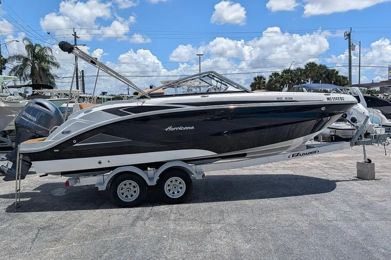 Slide: The Image of 2023 Hurricane SunDeck 235 OB boat on trailer under blue sky. - 2
