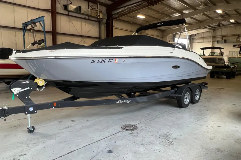 Slide: The Image of 2021 Sea Ray SPX 230 boat on trailer in indoor storage facility. - 0