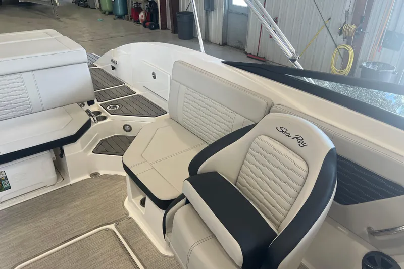 Slide: The Image of 2021 Sea Ray SPX 230 boat interior with white and black seating in a garage setting. - 5