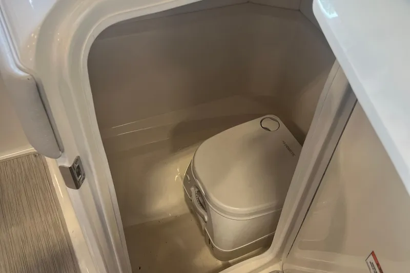 Slide: The Image of 2021 Sea Ray SPX 230 boat interior with compact portable toilet. - 9