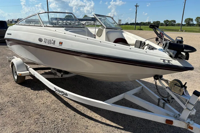 The Image of 2000 Crownline 180 BR boat on trailer, parked outdoors under a clear sky. - 1
