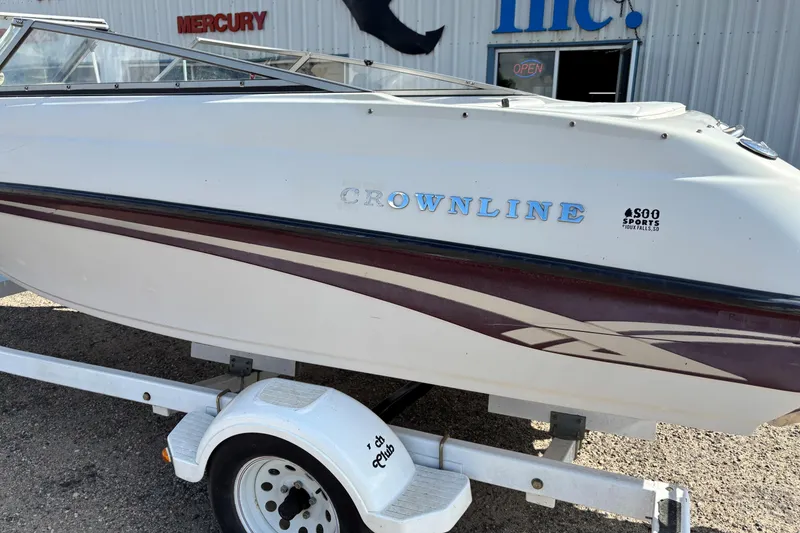 Slide: The Image of 2000 Crownline 180 BR boat on trailer, parked outside a building. - 3