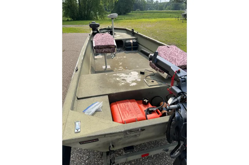 Slide: The Image of 2011 Tracker 1754 boat interior with seats, motor, and fuel tank on a sunny day. - 10