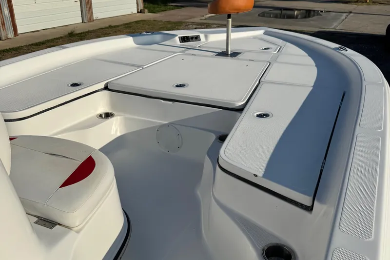 Slide: The Image of 2015 Epic 22 Sport Console boat interior with white seating and storage compartments. - 12