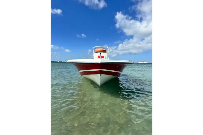 Slide: The Image of 2015 Epic 22 Sport Console boat on clear water under blue sky. - 2
