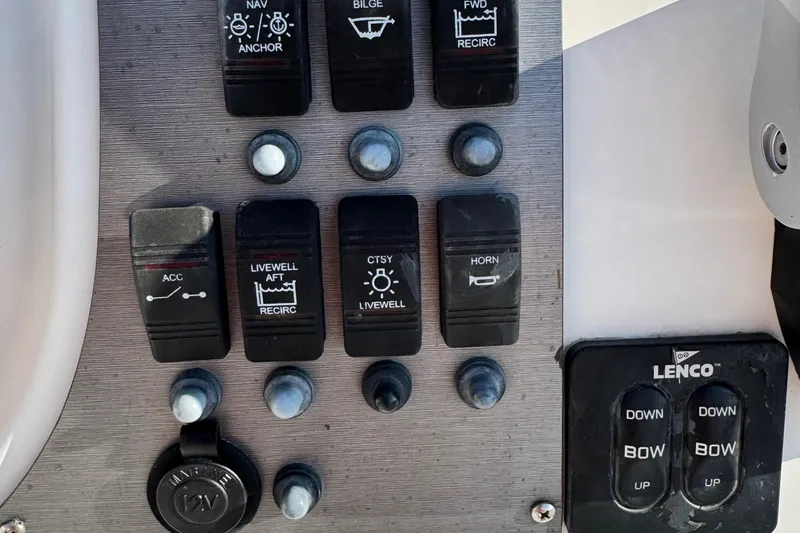 Slide: The Image of Control panel of a 2015 Epic 22 Sport Console boat with various switches and buttons. - 42