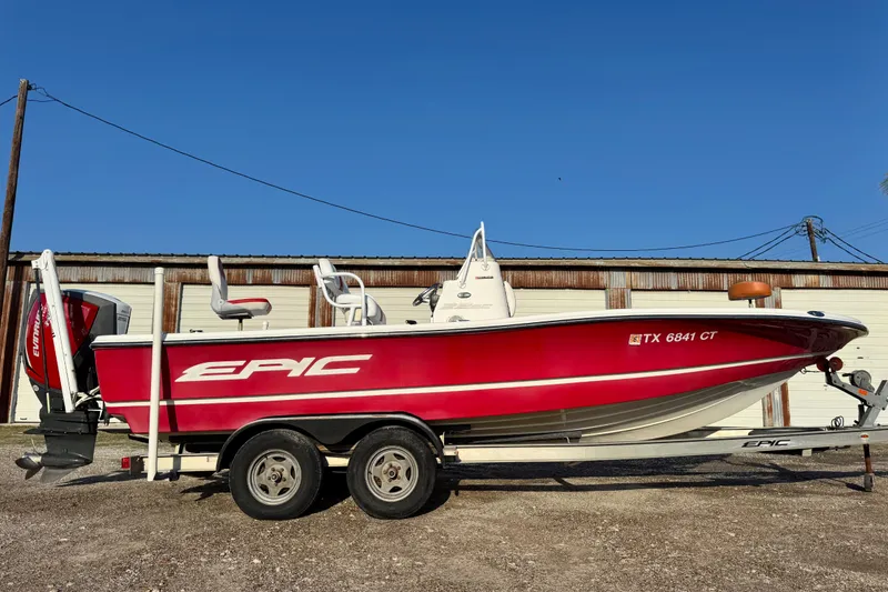 Slide: The Image of 2015 Epic 22 Sport Console boat in red on trailer, parked outdoors. - 6