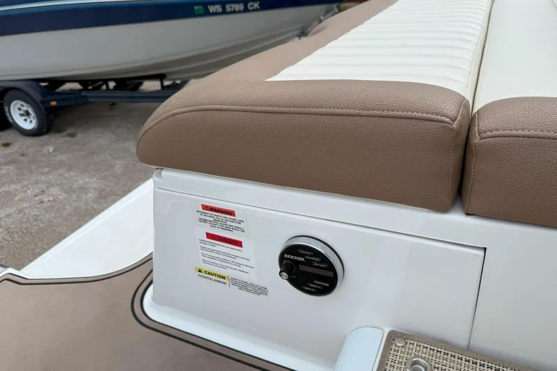 Slide: The Image of Cobalt 26SD 2016 boat seating area with control panel and warning labels. - 11