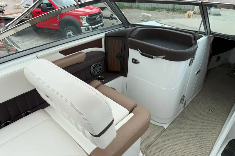 Slide: The Image of 2016 Cobalt 26SD boat interior with white and brown seating, visible dashboard, and speaker. - 14
