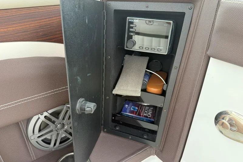 Slide: The Image of Storage compartment in a 2016 Cobalt 26SD boat with audio system and accessories. - 16