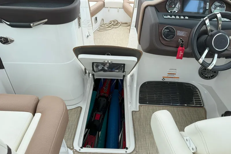 Slide: The Image of 2016 Cobalt 26SD boat interior with open storage compartment and steering wheel. - 30