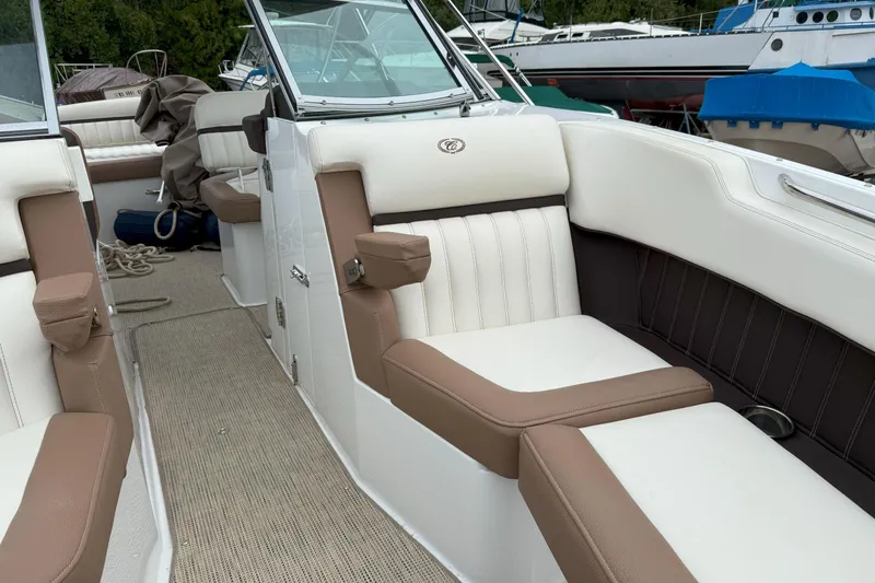 Slide: The Image of 2016 Cobalt 26SD boat interior with white and brown seating, docked outdoors. - 33