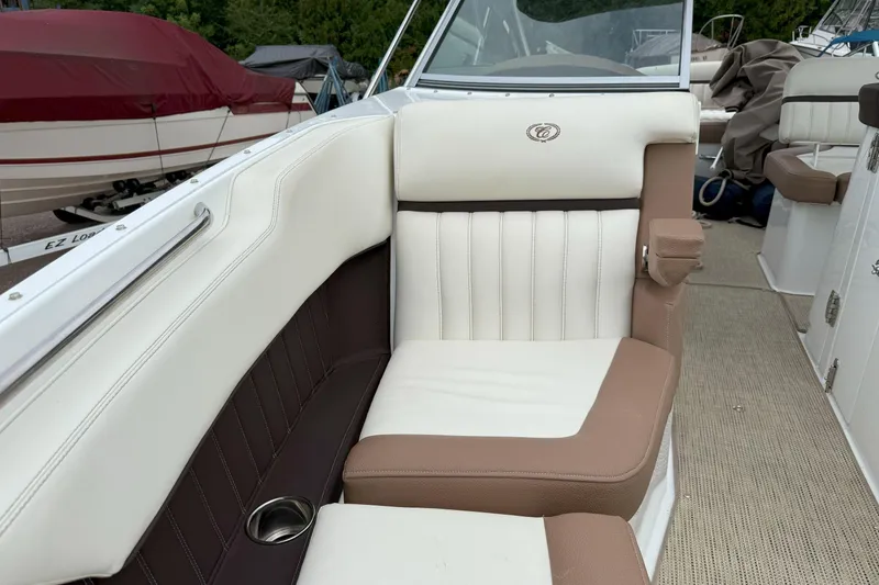Slide: The Image of 2016 Cobalt 26SD boat interior with beige and white seating, cup holder, and carpeted floor. - 35