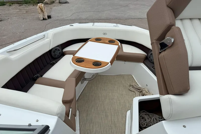 Slide: The Image of 2016 Cobalt 26SD boat interior with seating and table, featuring cup holders and beige upholstery. - 36