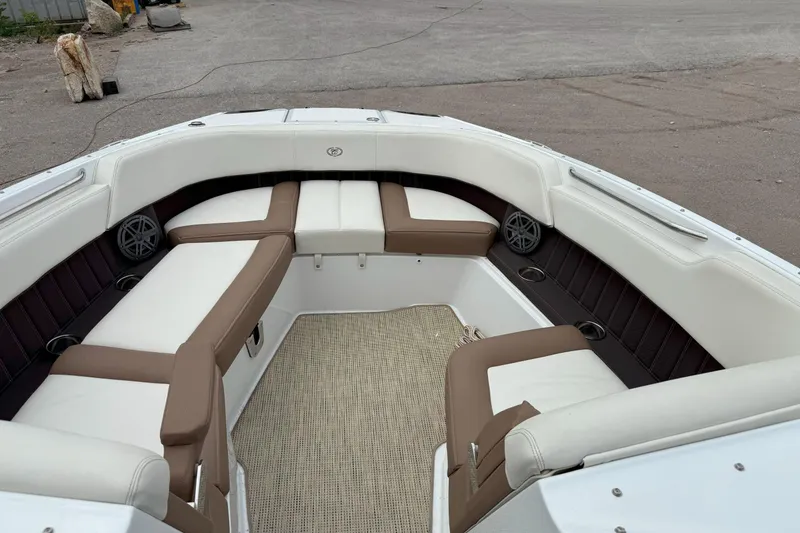 Slide: The Image of 2016 Cobalt 26SD boat interior with white and brown seating, outdoor setting. - 40